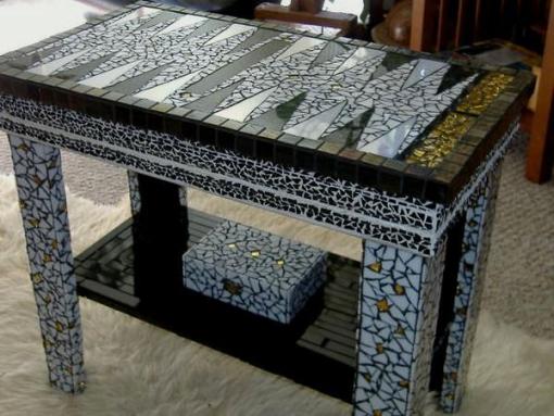 A stained glass backgammon table with intricate colored glass pieces from a recycled table.