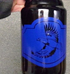 Small brown bottle with stencil prepared for etching.