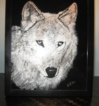 An animal engraving of a wolf in glass.