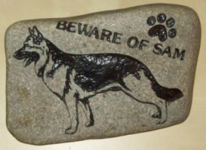 A sancarved rock depicting a dog graphic.