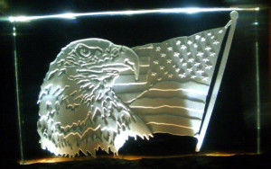 Sand carving an eagle and flag into jade glass.