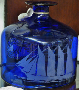 A blue glass jug etched with an old ship.