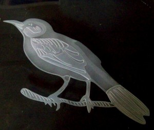 A 2 stage sandcarved bird in glass.