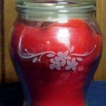 Etching a glass candle with a red background.