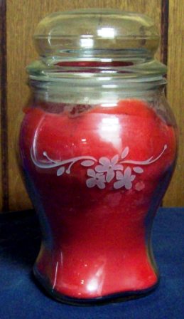 Etching a glass candle with a red background.