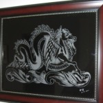 Engraving of a dragon by William K. on a framed glass art.