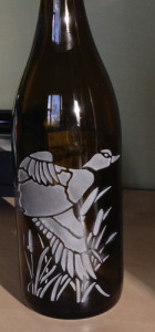 Duck engraved bottle photographed in evening hours.