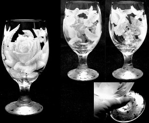 A flower and multiple doves shade engraved into a glass.
