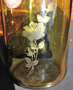 A rose etched on a cut glass wine bottle.
