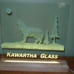 Sandblasted glass led sign with a wood stand and etched wolf.