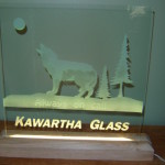 Sandblasted glass led sign with a wood stand and etched wolf.