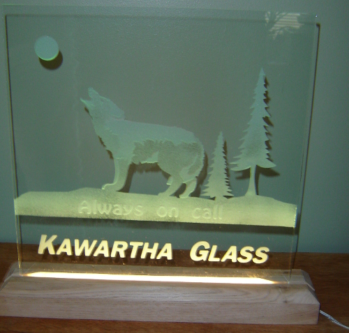 Sandblasted glass led sign with a wood stand and etched wolf.